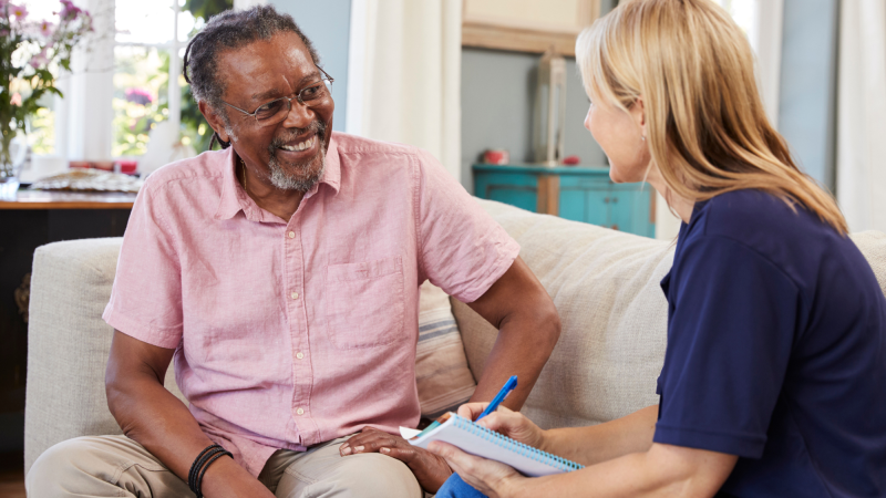 Black man at home with care worker